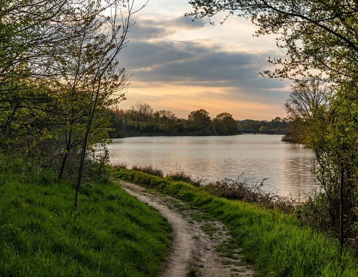 Vue panoramique du Lac de la Bultière entouré de verdure sous un ciel dégagé